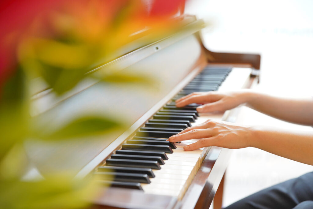 Close-up photo of a woman playing the piano in the room