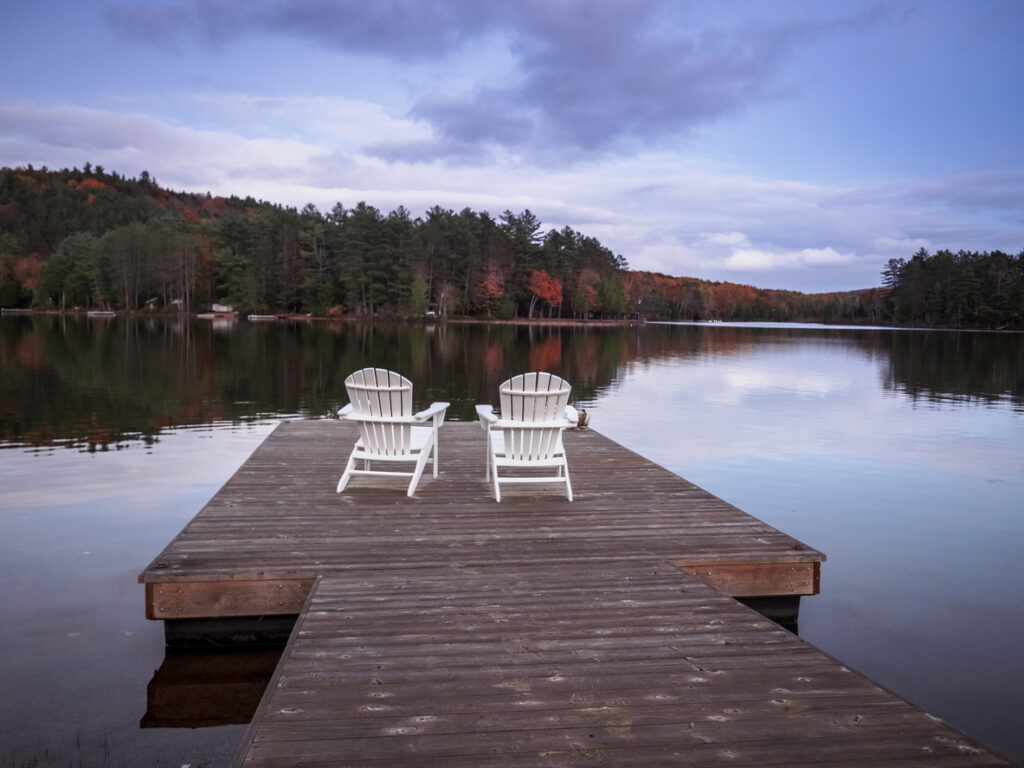 Two chairs in front of lake in Muskoka, Ontario, Canada during autumn